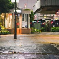 雨に濡れた池袋東口駅前の夜の街並みの写真