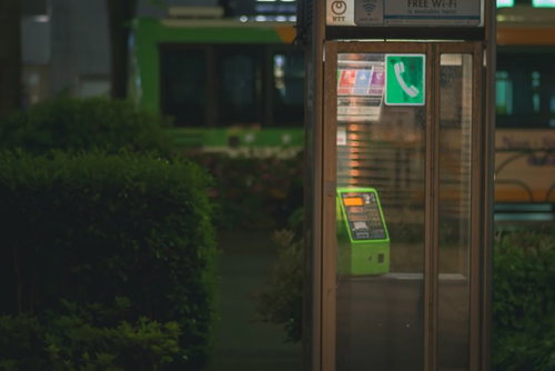雨粒に濡れる緑色の電話ボックス