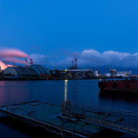 八戸港の工場夜景と赤いタンカー、照明に灯る煙突と水面の反映の写真