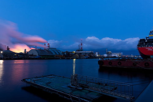 八戸港の工場夜景と赤いタンカー、照明に灯る煙突と水面の反映