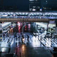 雨上がりの錦糸町駅前で横断歩道を渡る通行人たちの写真