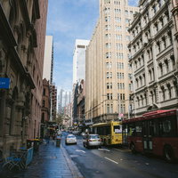 雨上がりの濡れた歩道に立ち並ぶビルの街並みの写真