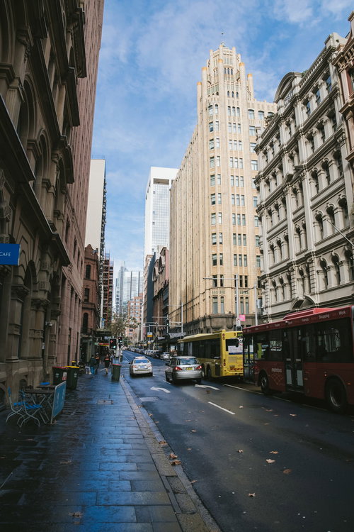 雨上がりの濡れた歩道に立ち並ぶビルの街並み