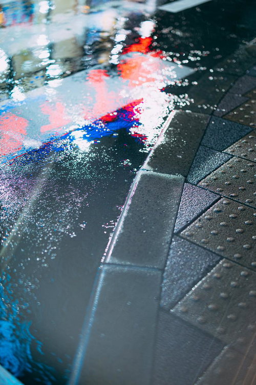 雨に濡れた路面に映るネオンの都市風景 - 夜の街並み