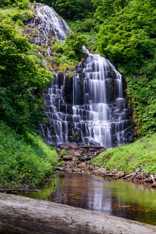 川に映り込む鳥海檜山滝と新緑の渓谷、柱状節理の岩肌