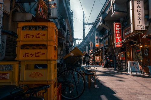 黄色いホッピーのケースが積み上げられたアメ横の路地裏の昼間風景