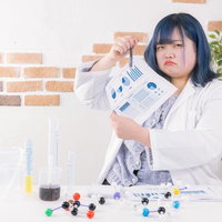 白衣を着たぽっちゃり理系女子の実験と資料確認の写真