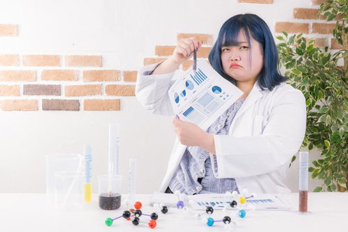 白衣を着た理系女子が実験資料と試験管を確認している