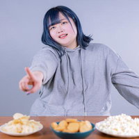 お菓子を指さしておねだりするぽっちゃり女子の写真
