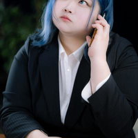 ぽっちゃりスーツ女子が電話で思案する姿勢の写真