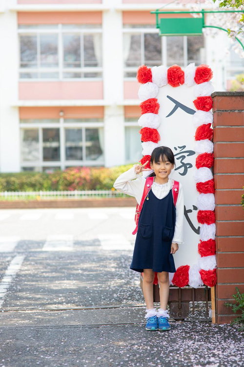 入学式でピースする小学生の女の子
