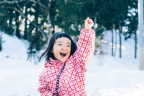 雪だるまつくるよー！ピンクチェック姿ではしゃぐ子どもの写真
