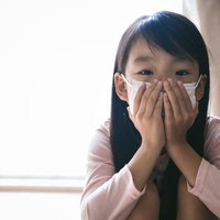インフルエンザ予防にマスクをする子供の健康管理の写真