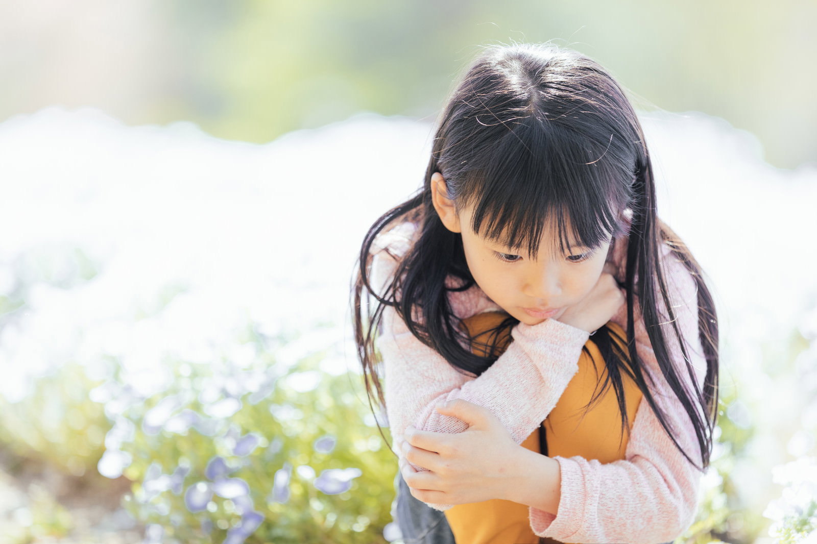 花畑でうつむいてうなだれている女の子［モデル：あんじゅ］