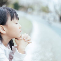 神様一生のお願いです。両手を合わせて祈る少女の写真