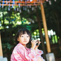 浴衣散歩で一休みするピンク色の浴衣姿の女の子の写真