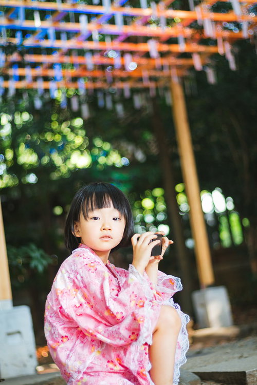 浴衣散歩で一休みするピンク色の浴衣姿の女の子