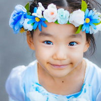 花飾りを着けたにっこり笑顔の女の子のポートレートの写真