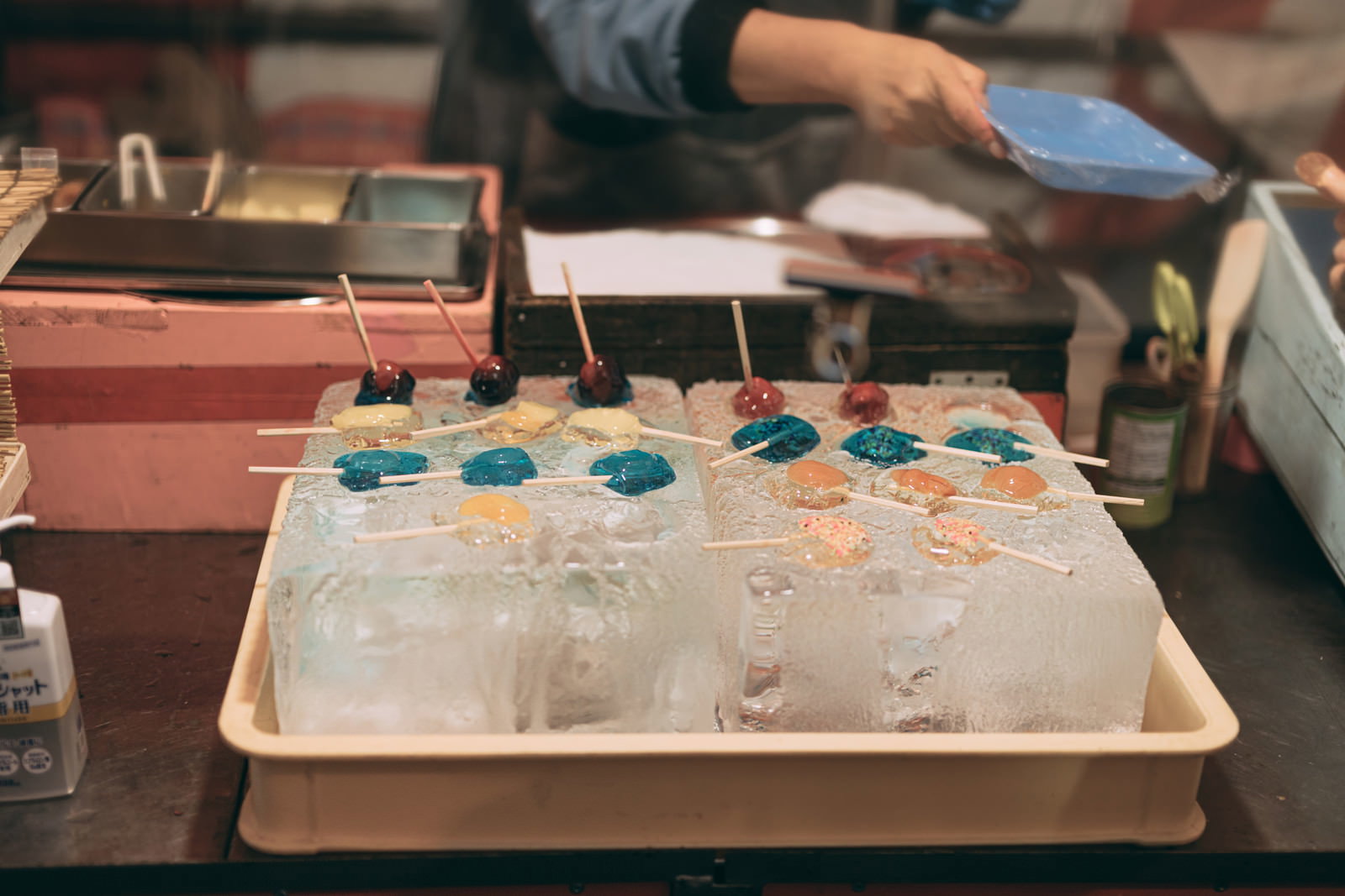 出店で販売されているあんず飴が木の棒に刺さって並んでいる様子