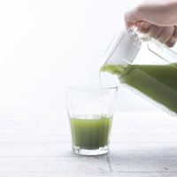 ポットからタンブラーに青汁を注ぐ様子を撮影した写真の写真