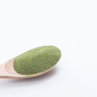 木製スプーン1杯の粉末青汁。抹茶風味の健康飲料の写真