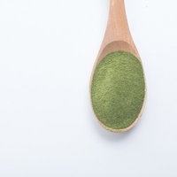 木製スプーンに盛った粉末青汁の写真