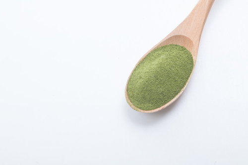 木製スプーンに盛られた粉末青汁の栄養食品