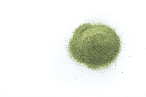 白い背景に盛られた粉末青汁の栄養補助食品