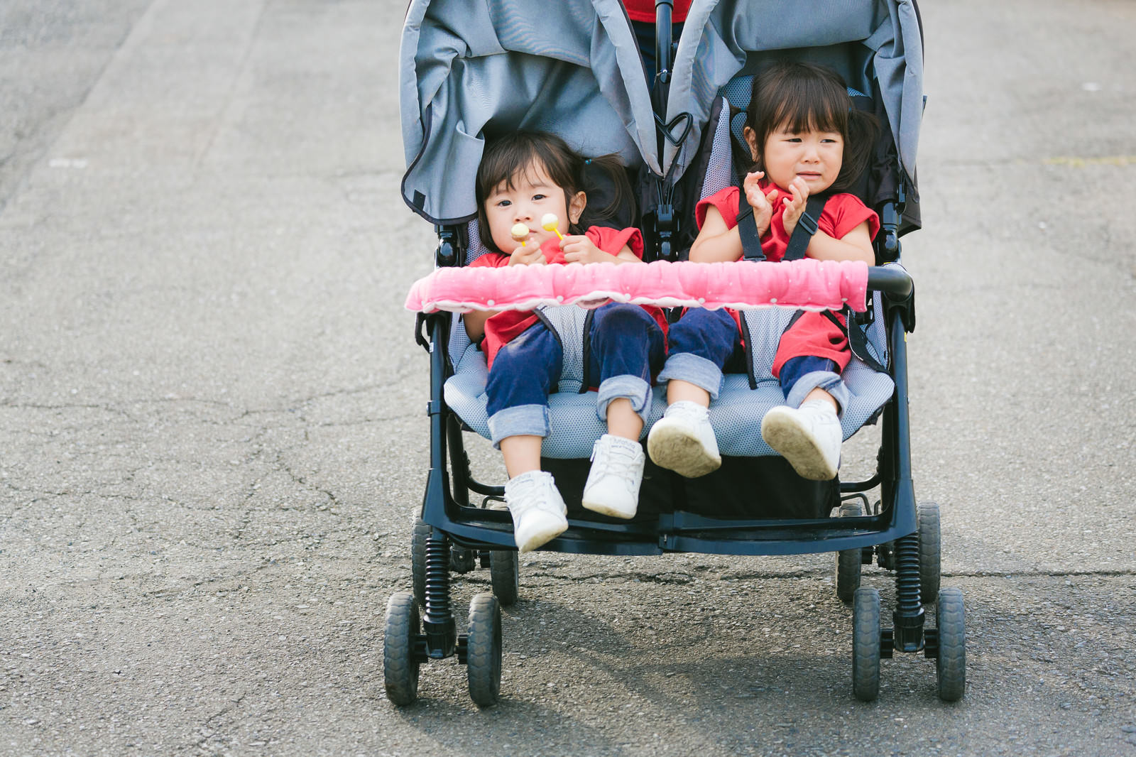 ベビーカーに座って泣いている双子の女の子［モデル：あおみどり］