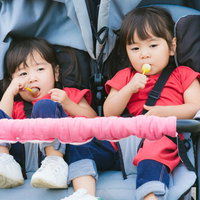 飴を与えたらおとなしくなった双子の子供たちの写真
