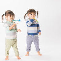 与えられたピロピロプーに夢中な子供（双子）の写真