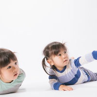 言うことを聞かない双子も興味津々、ツインテールの姉妹が床で指をさすの写真
