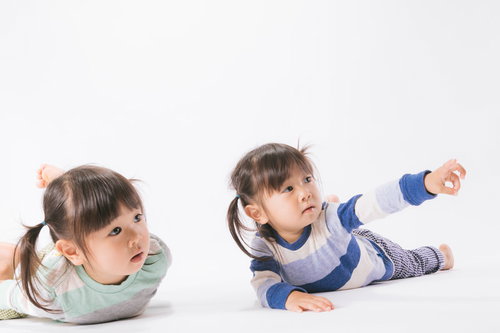 言うことを聞かない双子も興味津々、ツインテールの姉妹が床で指をさす