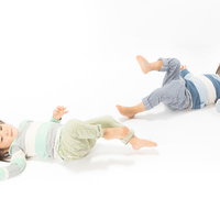 足を上げてイヤイヤする双子の女児姉妹、仲良く同じポーズで意思表示の写真
