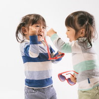 ボカスカ取り合いの喧嘩をする双子姉妹の真剣な表情の写真