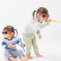 ピロピロプーで無邪気に遊ぶ双子の女の子たちの楽しい時間の写真