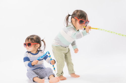 ピロピロプーで無邪気に遊ぶ双子の女の子たちの楽しい時間