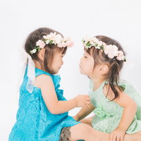 ねぇ、チューしてチュー。花冠を付けた双子の女の子の写真