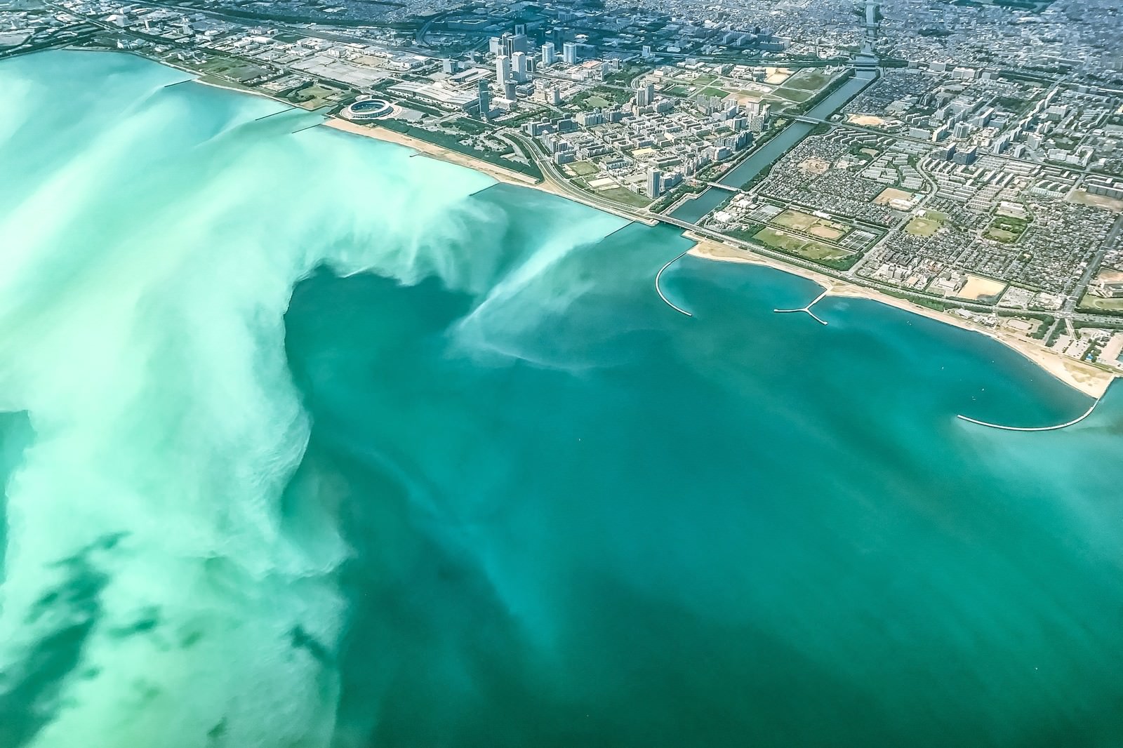 青潮により東京湾がエメラルドグリーン色に変色した空撮写真