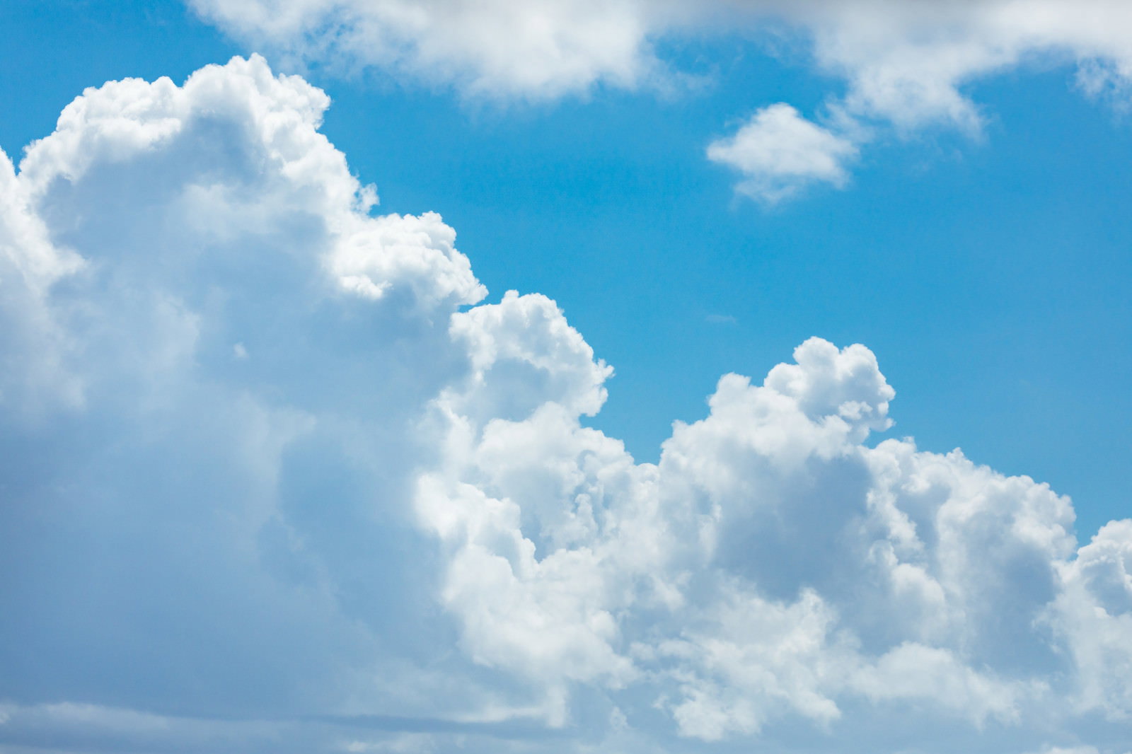青空に白い積乱雲が立体的に広がる夏の空模様