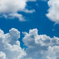 夏の青空にむくむく浮かぶ白い積乱雲の迫力ある成長の写真