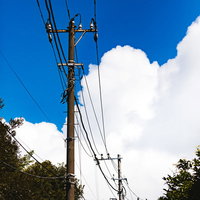 夏空に浮かぶ積乱雲と電柱の写真