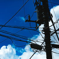 夏空に浮かぶ積乱雲と電信柱のシルエットの写真