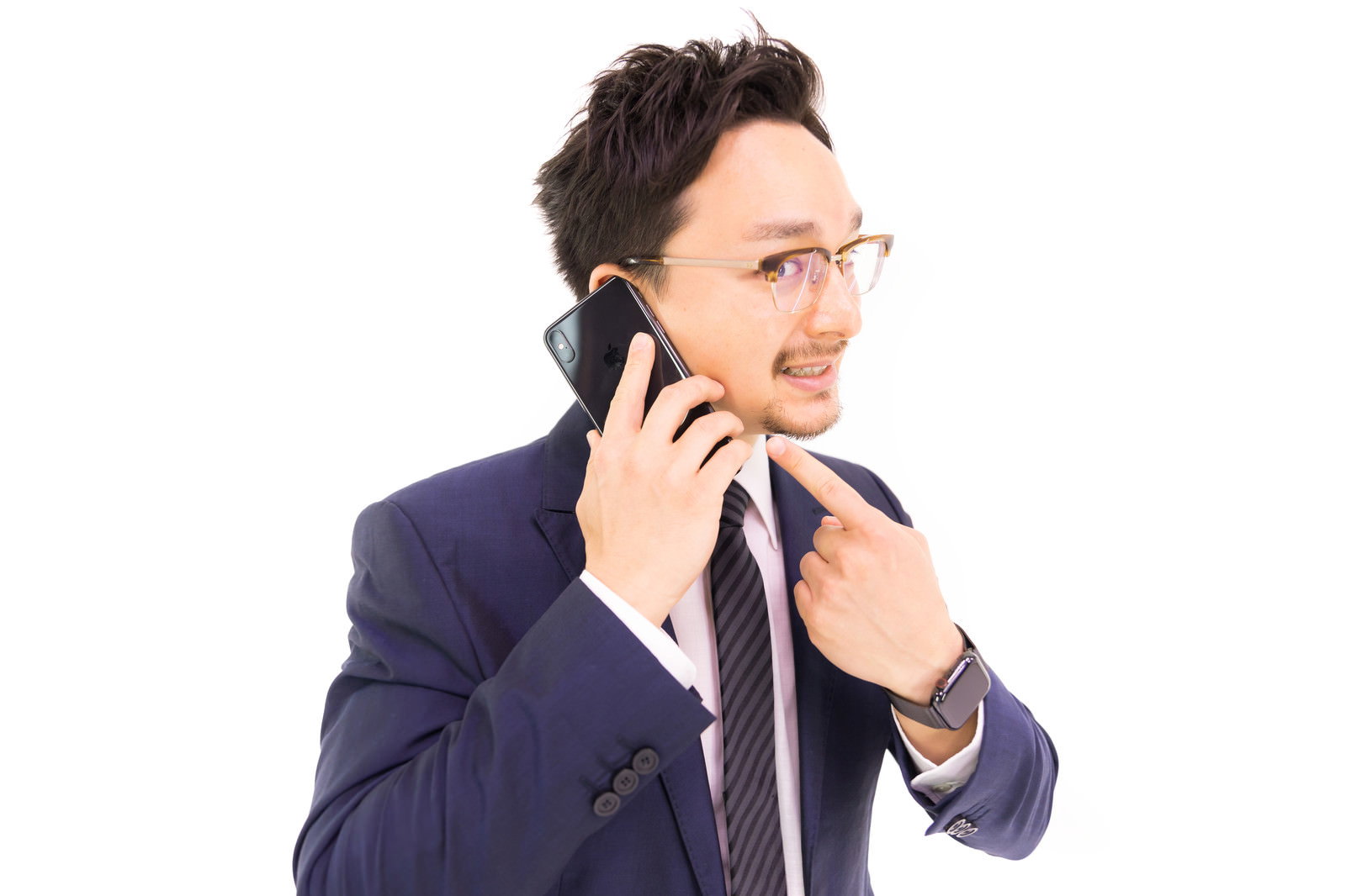 スーツの男性がスマートフォンで通話しながら説明［モデル：Max_Ezaki］
