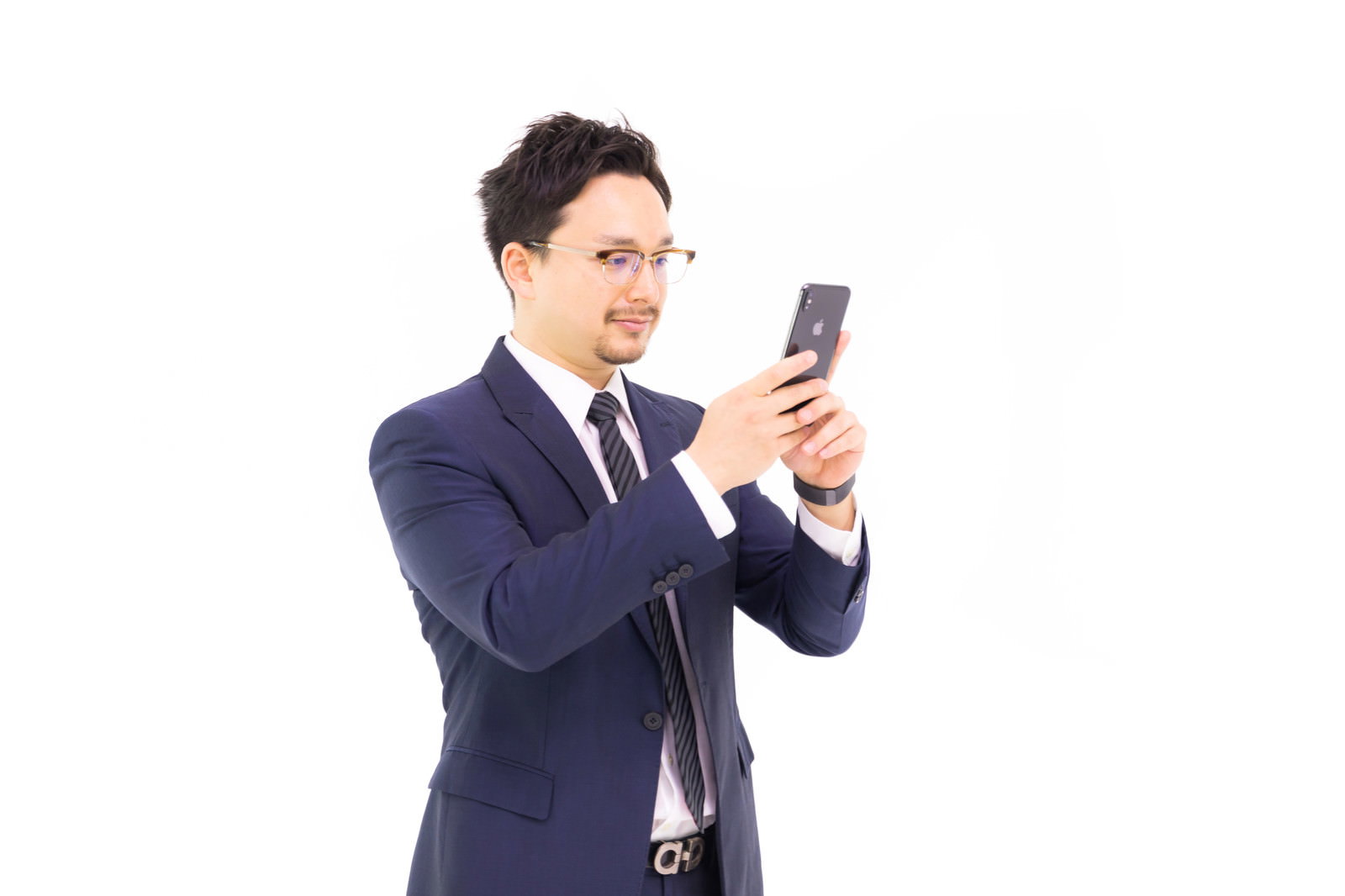 スーツ姿の男性がiPhoneを両手で持ち画面を見ている［モデル：Max_Ezaki］