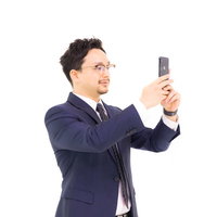 iPhoneを正面に向けて差し出すビジネスパーソンの手の写真