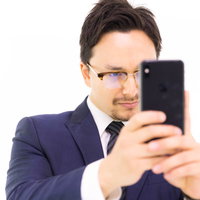 iPhone XS Maxで縦写真を撮る男性会社員の写真