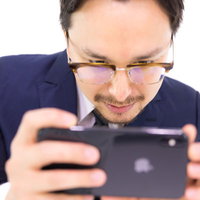 iPhone XS Maxで動画を見るビジネスマンの写真