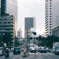 新宿の成子天神下交差点を行き交う車と人々の日常風景の写真