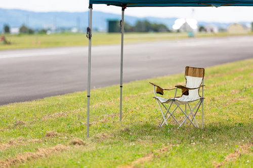 BBQの日陰に置かれた折りたたみ椅子でくつろぐ休憩スペース